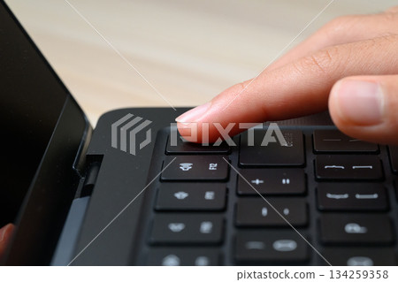 Close-up of a finger pressing the power button on a laptop Close-up of a finger pressing the power button on a laptop 134259358