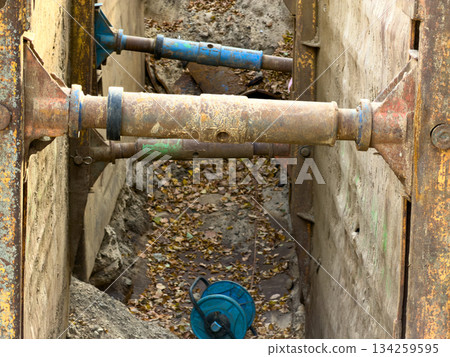 Heavy-duty rusty metal trench shoring box components firmly reinforce the deep excavation walls during crucial underground utility construction work, emphasizing site safety Heavy-duty rusty metal trench shoring box components firmly reinforce the deep excavation walls during crucial underground utility construction work, emphasizing site safety 134259595
