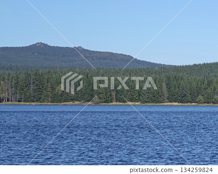 vast outdoor landscape imagery, peaceful lakeside view with mountain outline across wooded area vast outdoor landscape imagery, peaceful lakeside view with mountain outline across wooded area 134259824