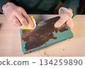 Man working at home workshop, sanding lamp base surface with sand paper, creative repairing process. 134259890