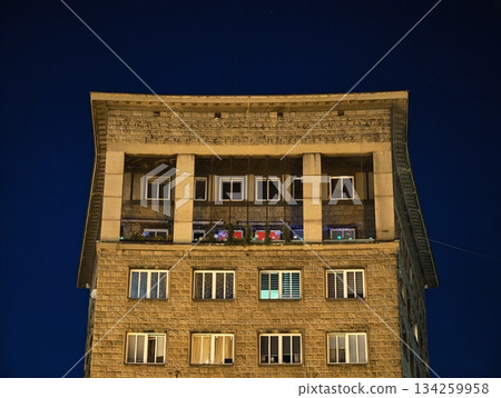 quiet urban building with nostalgic ambiance, serene city block illuminated by cozy yellow lights 134259958