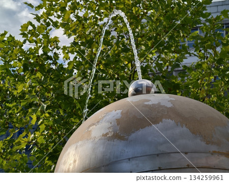 closeup view of tranquil stainless steel fountain with graceful arcs and shimmering droplets closeup view of tranquil stainless steel fountain with graceful arcs and shimmering droplets 134259961