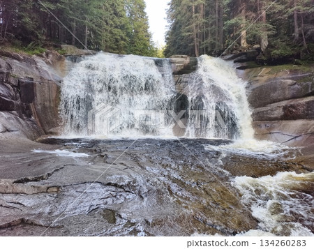 expansive twin cascade surrounded by forest, broader waterfall system amid lush trees and rocky slopes 134260283