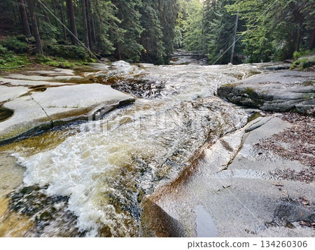white rapids crashing over stones, magnificent white torrent sweeping over rocks endlessly with spray 134260306