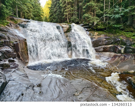 brightly lit waterfall showcasing soft hues surrounded by verdant moss and tranquil forest setting brightly lit waterfall showcasing soft hues surrounded by verdant moss and tranquil forest setting 134260313