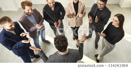 Banner with business team showing recognition to young man, clapping hands and smiling Banner with business team showing recognition to young man, clapping hands and smiling 134261969
