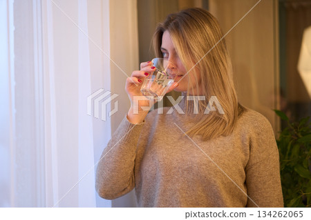 Quiet Sip of Water by the Softly Lit Window 134262065