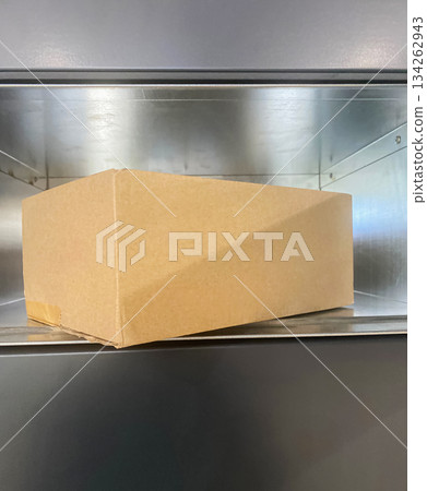 Open Gray Parcel locker with Cardboard box inside. 134262943