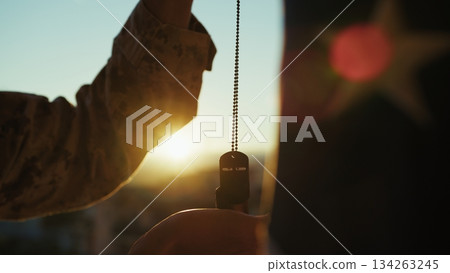 Silhouette Of A United States Soldier Holding A Dog Tag To Remember The Fallen Silhouette Of A United States Soldier Holding A Dog Tag To Remember The Fallen 134263245