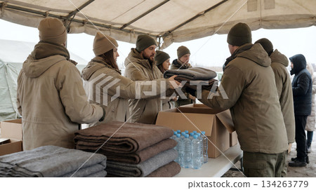 A relief activity site where volunteers distribute blankets and drinking water as relief supplies in cold regions A relief activity site where volunteers distribute blankets and drinking water as relief supplies in cold regions 134263779