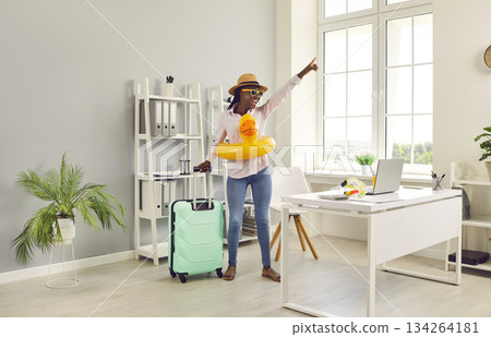 Happy business woman with suitcase and inflatable toy is ready for summer vacation 134264181