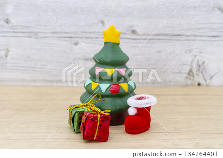 A miniature Christmas tree and presents placed on a wood background. Christmas and celebration image. A miniature Christmas tree and presents placed on a wood background. Christmas and celebration image. 134264401