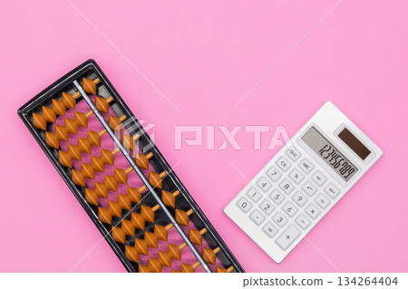 Abacus and calculator on a pink background. Image of calculation, business, education Abacus and calculator on a pink background. Image of calculation, business, education 134264404