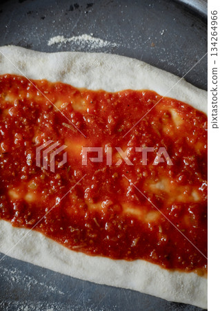 Spreading tomato sauce on pizza pan Spreading tomato sauce on pizza pan 134264966