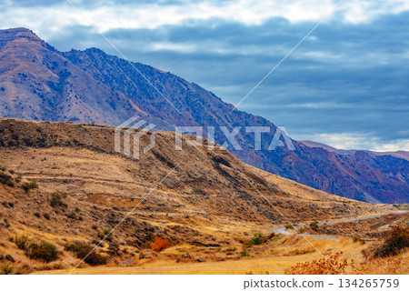 A mountain range with a cloudy sky in the background 134265759
