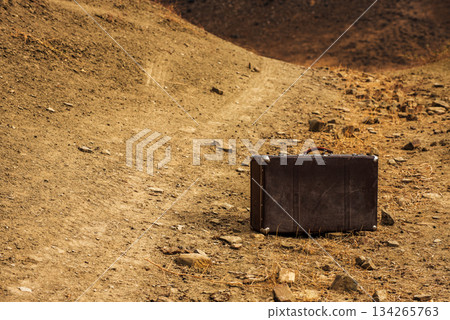 A suitcase is sitting on a rocky hillside A suitcase is sitting on a rocky hillside 134265763