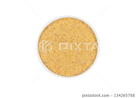 A bowl of yellow grains sits on a white background 134265788