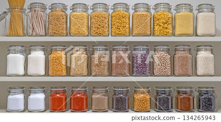 A shelf full of glass jars containing various spices and grains A shelf full of glass jars containing various spices and grains 134265943