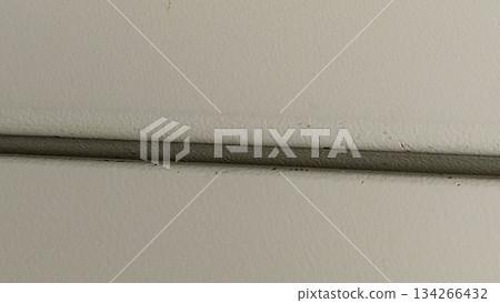Close-up of a shadow line groove between two white wall panels, showcasing a minimalist design element perfect for modern interiors. The image highlights clean lines and simplicity. Close-up of a shadow line groove between two white wall panels, showcasing a minimalist design element perfect for modern interiors. The image highlights clean lines and simplicity. 134266432