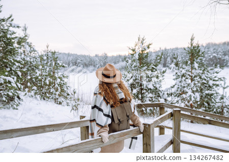 Woman traveler in a hat with a backpack on a wooden ladder. Active lifestyle. Travel concept. 134267482