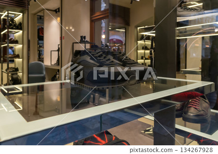 Black Sneakers On Glass Display In Modern Shoe Store Showroom With Reflections Ambient Lighting Atmosphere 134267928