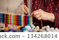 In Turkmenistan, hands skillfully tie and cut fine wool knots to create a colorful carpet. This traditional craft shows the effort and precision involved in carpet making. 134268014