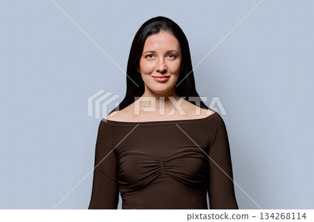 Portrait of beautiful smiling 40 years old woman posing on light gray background 134268114