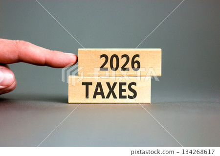 2026 taxes new year symbol. Concept words 2026 taxes on beautiful wooden blocks. Beautiful grey paper background. Businessman's hand. Business and 2026 taxes new year concept. Copy space. 2026 taxes new year symbol. Concept words 2026 taxes on beautiful wooden blocks. Beautiful grey paper background. Businessman's hand. Business and 2026 taxes new year concept. Copy space. 134268617