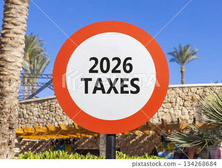 2026 taxes new year symbol. Concept words 2026 taxes on beautiful white and red road sign. Beautiful palm trees palm-trees and blue sky background. Business and 2026 taxes new year concept. Copy space 2026 taxes new year symbol. Concept words 2026 taxes on beautiful white and red road sign. Beautiful palm trees palm-trees and blue sky background. Business and 2026 taxes new year concept. Copy space 134268684