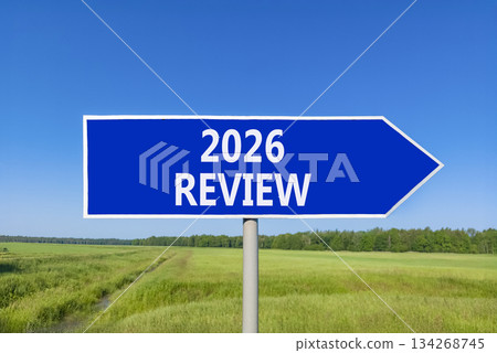 2026 Review symbol. Concept words 2026 Review on beautiful blue road sign. Beautiful green grass field forest and blue sky background. Business and 2026 review concept. Copy space. 134268745