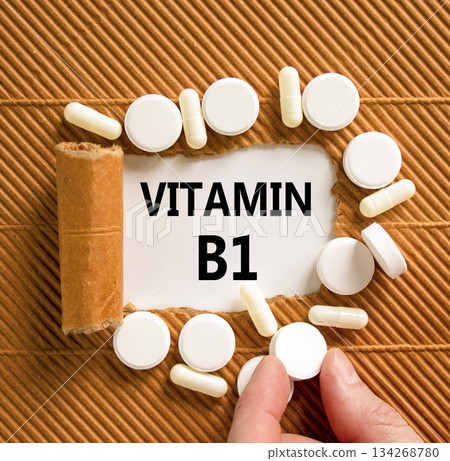 Vitamin B1 symbol. Concept words Vitamin B1 on beautiful white paper. White pills tablets. Doctor's hand. Beautiful brown background. Medical healthy lifestyle Vitamin B1 concept. 134268780