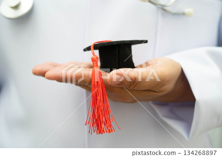 Asian woman doctor holding graduation hat in hospital, Medical education concept. Asian woman doctor holding graduation hat in hospital, Medical education concept. 134268897