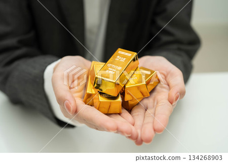 Asian woman holding gold bar in finance business. 134268903