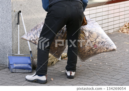 Yokohama cityscape in Japan December...Aging society An elderly man sweeping up fallen leaves...What kind of society is it where people have to work even at an advanced age? 134269054