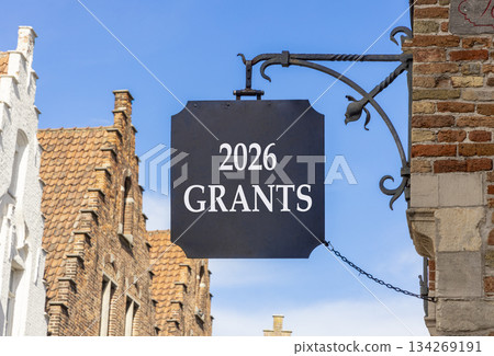 2026 Grants symbol. Concept words 2026 Grants on beautiful black road sign. Beautiful street and buildings in Brugge blue sky background. Business and 2026 grants concept. Copy space. 2026 Grants symbol. Concept words 2026 Grants on beautiful black road sign. Beautiful street and buildings in Brugge blue sky background. Business and 2026 grants concept. Copy space. 134269191