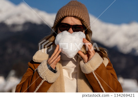 Snow Heart Woman Winter: Mountains, sunny day, playful snowy heart pose for Valentine's Day. Snow Heart Woman Winter: Mountains, sunny day, playful snowy heart pose for Valentine's Day. 134269421