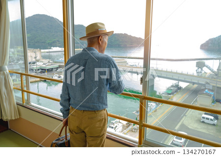 一位老人正望著窗外的港口。 134270167