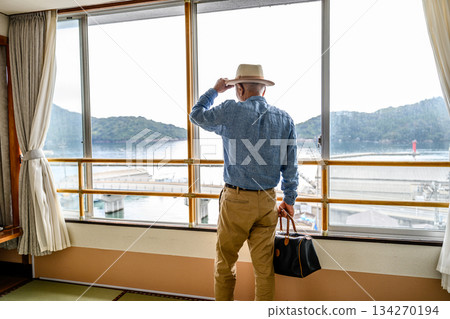 A traveler looking out the window at the sea and islands A traveler looking out the window at the sea and islands 134270194