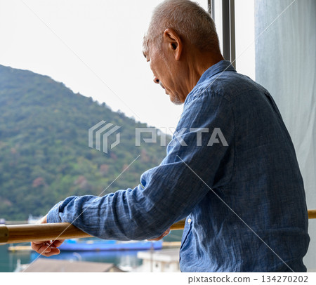 一位老人正望著窗外的風景。 134270202