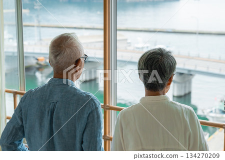 一對老夫婦正望著窗外的大海。 134270209