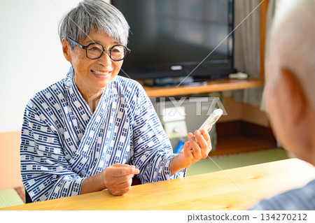 一對夫婦正在和一位身穿浴衣的老婦人聊天。 134270212
