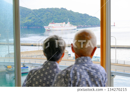 一對老夫婦正望著窗外的渡輪和大海。 134270215