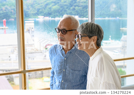 一對老夫婦正從窗戶眺望大海。 134270224