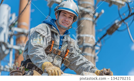 A scene of an electrician working at height on a utility pole A scene of an electrician working at height on a utility pole 134270231