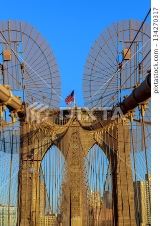 Brooklyn Bridge view with American flag in New York City 134270317