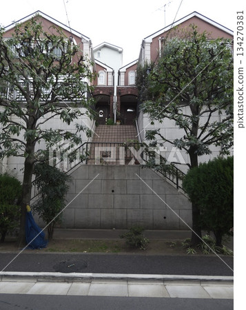 Two symmetrical Western-style houses and stairs built on top of a retaining wall on high ground Two symmetrical Western-style houses and stairs built on top of a retaining wall on high ground 134270381