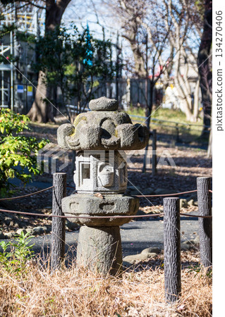 A stone lantern surrounded by ropes in a park under bright sunlight at Asukayama Park in Oji, Tokyo A stone lantern surrounded by ropes in a park under bright sunlight at Asukayama Park in Oji, Tokyo 134270406