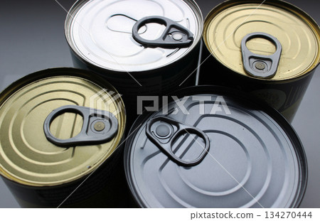 Variety types of keys on four cans of long life food products. Canned preserves in variety containers close up view 134270444