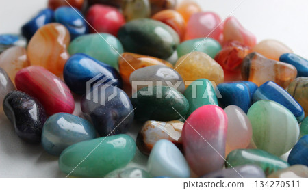 Heap of raw glance semi precious colored stones on a white surface closeup angle view 134270511