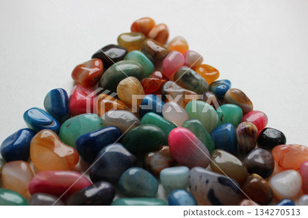 A slide of shiny multi-colored quartz stones isolated on white stock photo for stones backgrounds A slide of shiny multi-colored quartz stones isolated on white stock photo for stones backgrounds 134270513